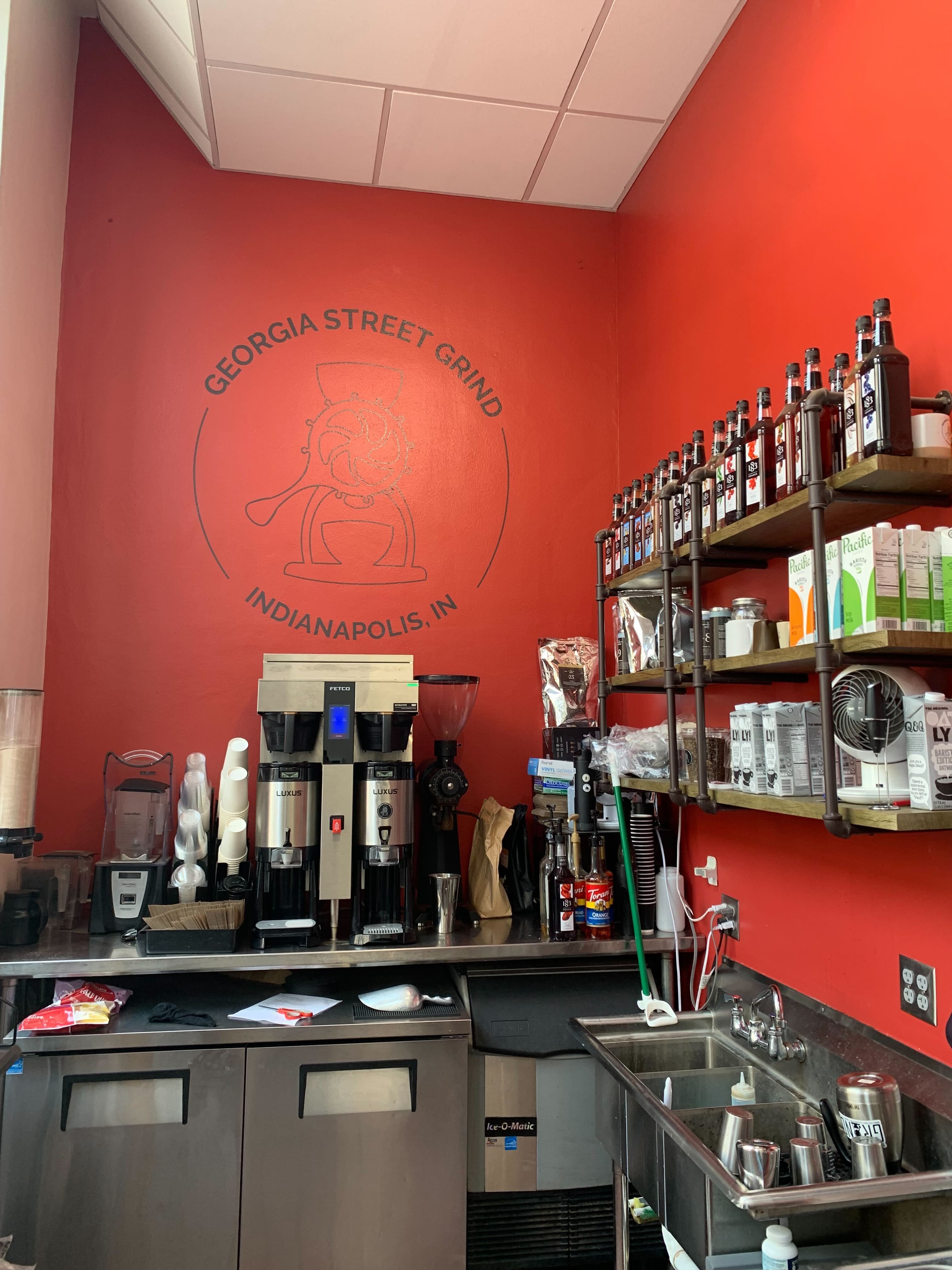 Georgia Street Grind bar — red wall with logo mural, espresso equipment